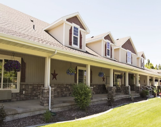 Exterior of a welcoming residential home with a covered front porch, dormer windows, and stone accents